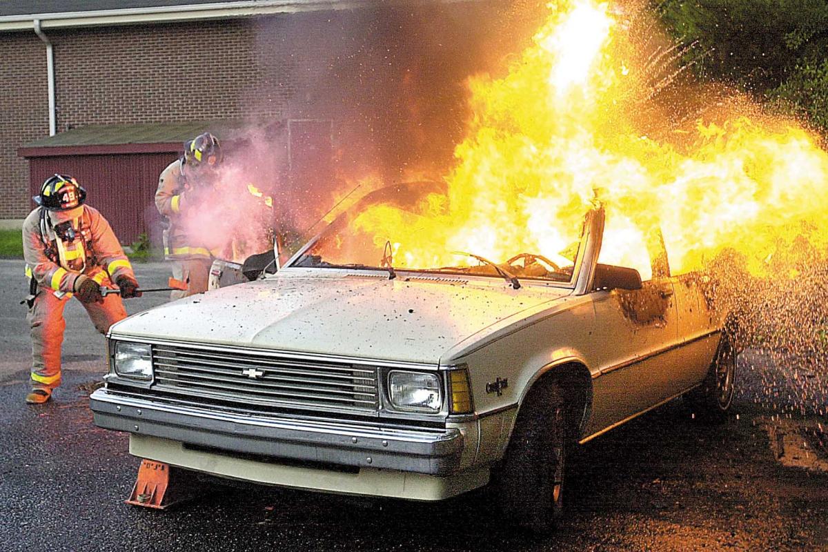 Firefighter demonstrating how to handle a car that is engulfed in flames